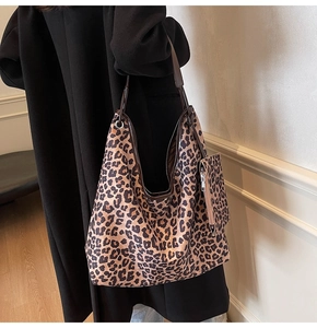 Macro view of leopard print tote bag detailing textured fabric and matching coin purse pouch