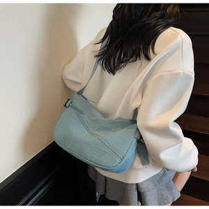 Detail of light blue hobo bag showing nylon texture and adjustable shoulder strap