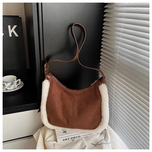 Dettaglio borsa sottobraccio in pelle scamosciata con bordo in peluche e tracolla
