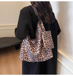Detail view of large leopard print tote bag set with matching pouch on shoulder
