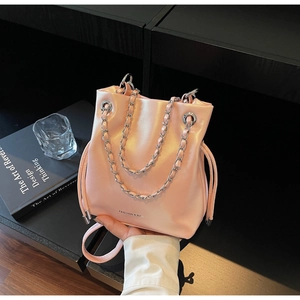 Detail of pink leather bucket bag with silver chain handle and drawstring closure