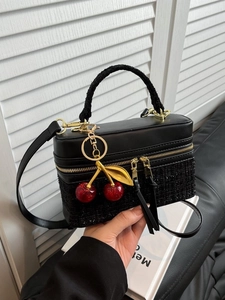 Black mixed-material handbag with tweed detail, gold hardware and cherry charm accessory