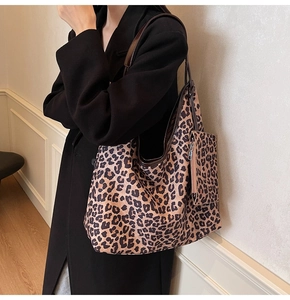 Detailed view of leopard print tote bag with matching pouch shown on a fashion model