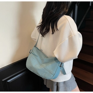 Detail of light blue nylon crossbody bag with adjustable strap and casual wrinkled texture