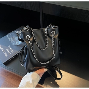 Detail of black PU leather bucket bag with silver chain straps and drawstring design