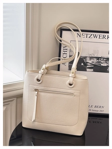 Detailed macro view of off-white tote bag with lychee texture and front zipper pocket
