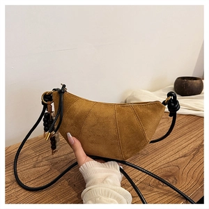 Detail of camel suede crescent bag with knot strap and decorative wood beads