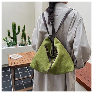 Outdoor shot of green quilted suede backpack featuring brown slim leather straps