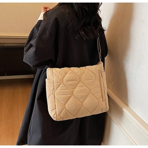 Detailed back view of a beige quilted tote bag showing large diamond stitch patterns