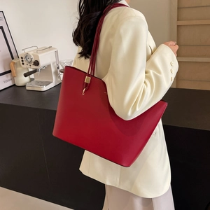 Chic red large capacity leather tote bag for women shown in a modern lifestyle setting
