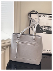 Detail of grey lychee texture leather tote bag featuring gold hardware and outer zipper