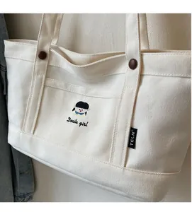 Detailansicht der cremefarbenen Canvas-Tasche mit Stickerei und Docile girl Schriftzug
