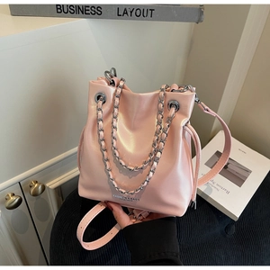 Detail of pink glossy bucket bag with silver chain handle and fashion text design