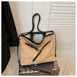 Detail of khaki suede quilted hobo bag with black leather straps and gold buckle