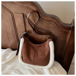 Dettaglio della borsa hobo in camoscio marrone scuro con bordo in ecopelliccia bianca