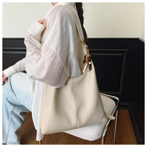 Detail of off-white large capacity leather tote bag with wooden bead charm pendant