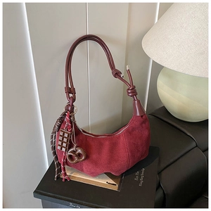 Vue détaillée du sac hobo en suédine bordeaux avec pendentifs pretzel et chocolat