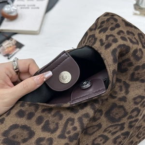 Détail du fermoir magnétique d'un sac cabas en suédine avec imprimé léopard sauvage