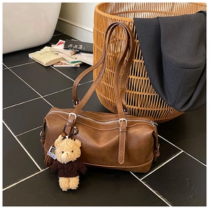 Brown vintage faux leather Boston bag with teddy bear charm and adjustable shoulder strap