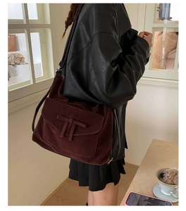 Detailed view of the dark brown suede hobo bag featuring a classic T-shaped decorative strap