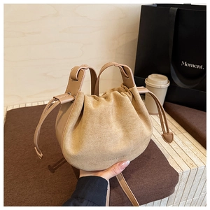 Nahaufnahme der khaki Plissee-Tasche mit Wildleder-Textur und Kordelzug-Verschluss
