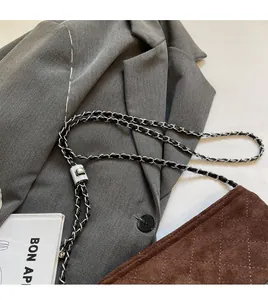 Détail de la bandoulière en chaîne entrelacée et boucle argentée sur un sac matelassé