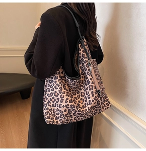 Detailed side view of large leopard print tote bag with small matching pouch attachment