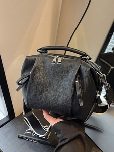 Chic black litchi leather pillow bag with stylish black and white wide woven strap