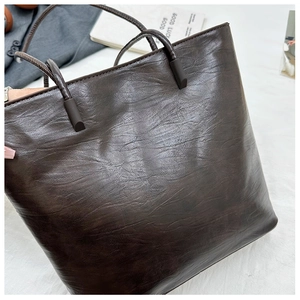 Detail of dark brown tote bag with vintage wrinkled leather texture and large capacity