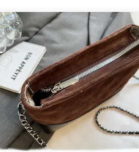 Détail macro de la fermeture éclair sur le sac seau matelassé en daim marron givré