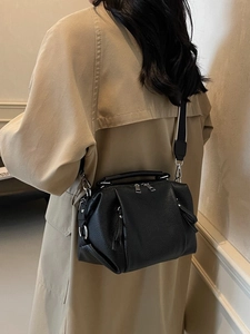 Fashionable black pebbled leather crossbody bag with wide black and white woven strap