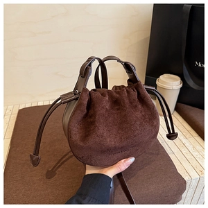 Detailansicht der braunen Wildleder Beuteltasche mit Kordelzug und einem Ledergriff