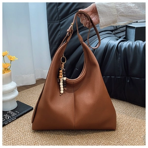 Detailed close-up of brown pebbled leather hobo bag with ethnic style beaded tassel