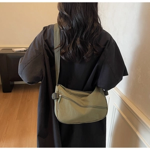 Detail of army green nylon crescent bag with textured fabric and crossbody strap