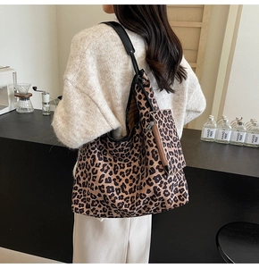 Detail of leopard print tote bag with small zipper pouch in a cozy cafe setting