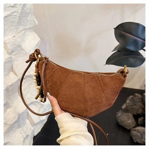 Detail of brown suede half-moon bag with wooden beads and elegant leather strap
