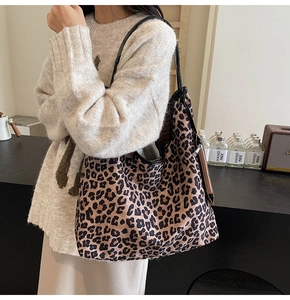 Detailed view of the large capacity leopard print tote bag with black leather straps