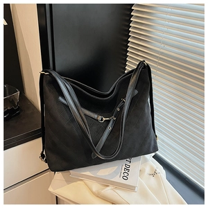 Detailed view of black quilted tote bag featuring matte texture and elegant golden hardware