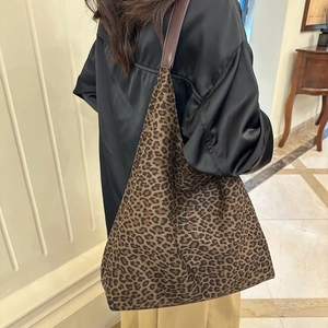 Détail latéral du sac seau hobo à imprimé léopard avec bandoulière en cuir brun