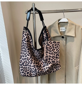 Detail of leopard print tote bag with matching pouch on minimalist beige trench coat