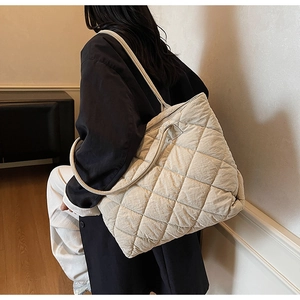 Gros plan sur un sac cabas matelassé beige avec couture en losange et grande capacité