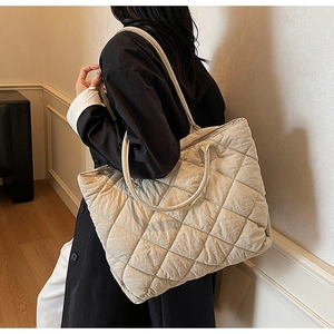Gros plan du sac fourre-tout matelassé beige avec grand volume et motif de losanges