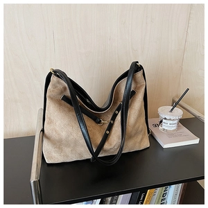Detail of khaki quilted rhombic hobo bag with dual straps on a display stand