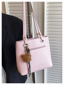 Detailed texture of pink lychee leather tote bag with a cute brown plush bear charm
