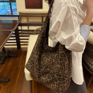 Gros plan sur un sac seau en daim à motif léopard porté à l'épaule pour le style chic