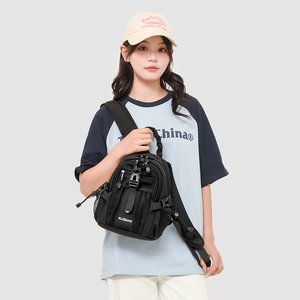 Detail of black multi-pocket sling bag showing adjustable strap and mesh pocket on chest