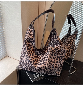 Detail of leopard print tote bag with brown leather strap and matching small pouch