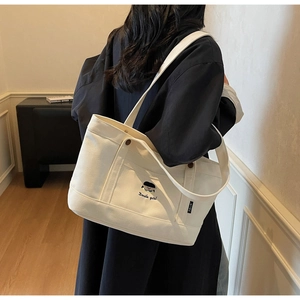 Detailaufnahme der beigen Canvas-Tasche mit Stickerei und Docile girl Schriftzug