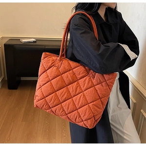 Vue détaillée du grand sac cabas matelassé orange avec motif à losanges porté par le mannequin