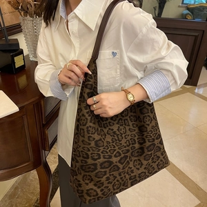 Gros plan du sac cabas à motif léopard avec des anses en cuir noir en intérieur rétro